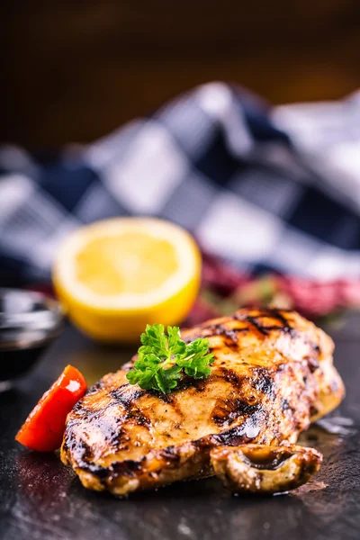 Poitrine de poulet grillée en différentes variantes avec tomates cerises, champignons, herbes, citron coupé sur une planche en bois ou une casserole en téflon. Cuisine traditionnelle. Cuisine grill — Photo