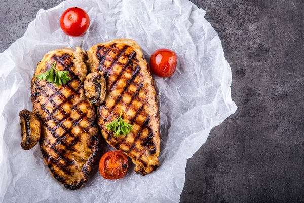 Grillowane piersi kurczaka w różnych odmianach z pomidorami wiśniowymi, grzybami, ziołami, pokrojoną cytryną na drewnianej desce lub patelni teflonowej. Tradycyjna kuchnia. Kuchnia grillowa — Zdjęcie stockowe