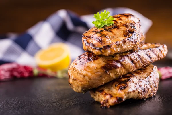 Grilled chicken breast in different variations with cherry tomatoes,  mushrooms, herbs, cut lemon on a wooden board or teflon pan. Traditional cuisine. Grill kitchen — Stock Photo, Image