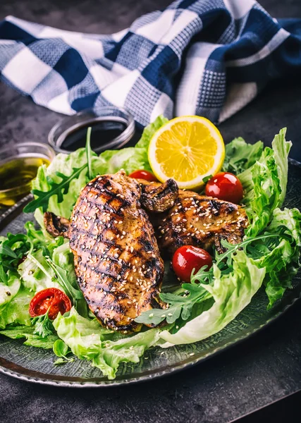 Grilled chicken breast in different variations with lettuce salad cherry tomatoes  mushrooms herbs cut lemon on a wooden board or teflon pan. Traditional cuisine. Grill kitchen — Stock Photo, Image