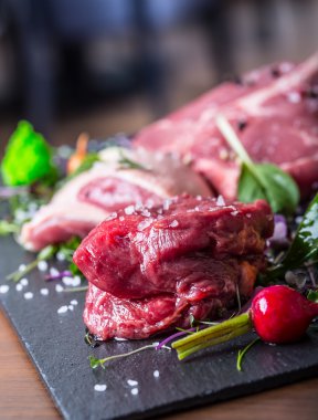 Biftek.Biftek. Et.Porsiyonluk et. Çiğ taze et. Sığır filetosu bifteği. T-Bone bifteği. Böğür bifteği. Ördek göğsü. Sebze dekorasyonu. Bir restoran veya otel mutfağında işlenmek için hazırlanmış porsiyonlu et