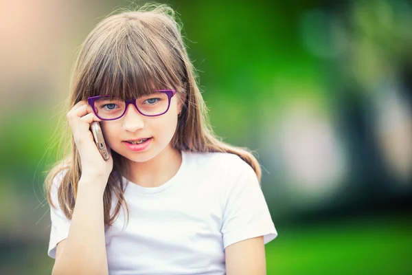 アイスクリームと携帯電話で晴れた日に公園でかわいい女の子 — ストック写真