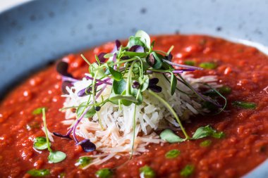 Çorba. Domates çorbası. İtalyan domates çorbası. Akdeniz domates çorbası. İtalyan cuicsine. Akdeniz yemekleri. Peynir ve mikro bitki dekorasyon ile Domates çorbası. Bir kaşıküzerinde domates çorbası porsiyon