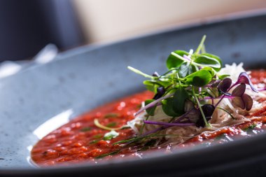 Çorba. Domates çorbası. İtalyan domates çorbası. Akdeniz domates çorbası. İtalyan cuicsine. Akdeniz yemekleri. Peynir ve mikro bitki dekorasyon ile Domates çorbası. Bir kaşıküzerinde domates çorbası porsiyon