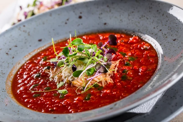 Çorba. Domates çorbası. İtalyan domates çorbası. Akdeniz domates çorbası. İtalyan cuicsine. Akdeniz yemekleri. Peynir ve mikro bitki dekorasyon ile Domates çorbası. Bir kaşıküzerinde domates çorbası porsiyon
