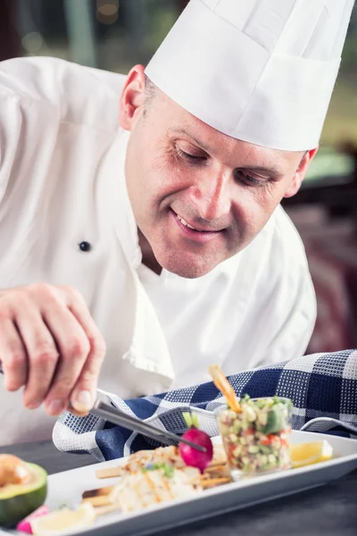 Chef. Chef cooking.Chef decorating dish. Chef preparing a meal. Chef in hotel or restaurant kitchen prepares decorating dish with tweezers. Chef cooking, only hands