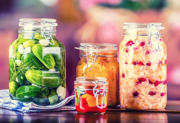 Preserving. Pickles jars. Jars with pickles, pumpkin dip, white cabbage, roasted red yellow pepper. Pickled Vegetables. Vegetable being prepared for preserving. Toned image