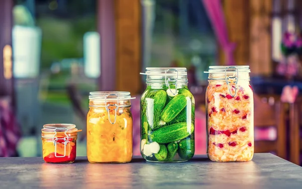 Preserving. Pickles jars. Jars with pickles, pumpkin dip, white cabbage, roasted red yellow pepper. Pickled Vegetables. Vegetable being prepared for preserving. Toned image — Stock Image Preserving. Pickles jars. Jars with pickles, pumpkin dip, white cabbage, roasted red yellow pepper. Pickled Vegetables. Vegetable being prepared for preserving. Toned image Stock Image