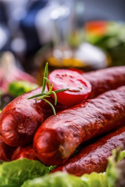 Sosis. Chorizo sosisi. Sebze dekorasyonlu çiğ füme sosis. Marul salatası ot biberiye domates sarımsak zeytinyağı