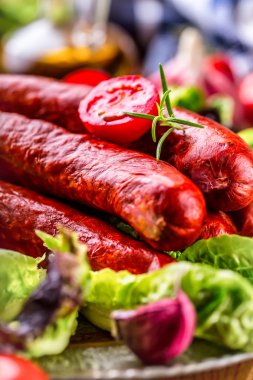Sosis. Chorizo sosisi. Sebze dekorasyonlu çiğ füme sosis. Marul salatası ot biberiye domates sarımsak zeytinyağı