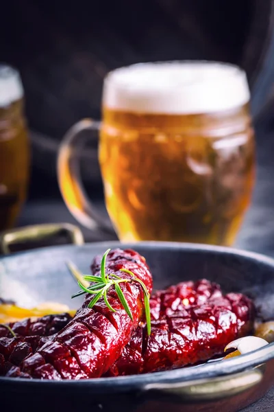 Klobása. Pražený uzené. Pečené kořeněné klobásy (domácí Hotel nebo Restaurace) s pivem z kokosových pálenek whisky. Ještě život. Tonované Foto — Stock fotografie