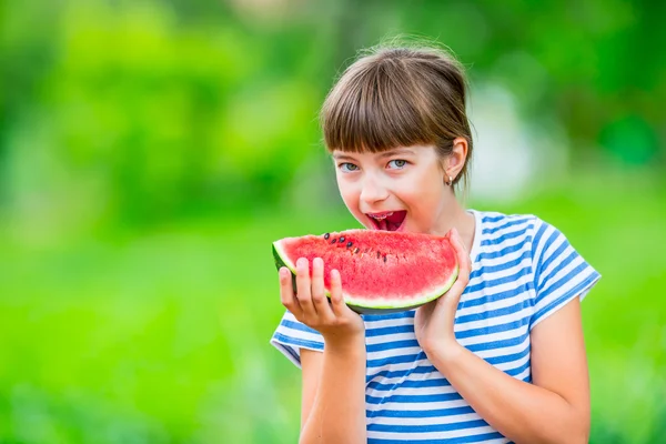 Child eating watermelon. Kids eat fruits in the garden. Pre teen girl in the garden holding a slice of water melon. happy girl kid eating watermelon. Girl kid with gasses and teeth braces — Stock Photo, Image