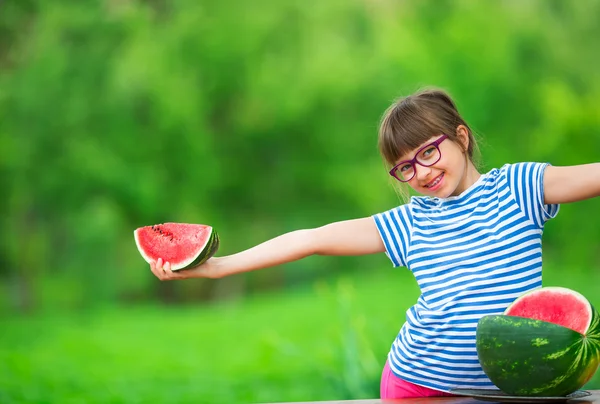 Niño comiendo sandía. Los niños comen frutas en el jardín. Pre adolescente en el jardín sosteniendo una rebanada de sandía. niña feliz comiendo sandía. Niña con gases y aparatos ortopédicos — Foto de Stock