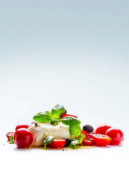 Caprese. Capresesallad. Italiensk sallad. Medelhavsinspirerad sallad. Italiensk mat. Medelhavsmat. Tomat mozzarella basilika blad svarta oliver och olivolja över vita. Recept - ingredienser — Stockfoto