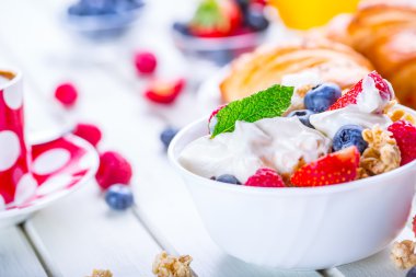 Yoğurt ve ahşap bir masa üzerinde meyveleri ile müsli. Sağlıklı meyve süt yogurth ve Mısır gevreği brakfast
