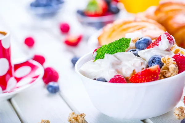 Muesli con yogur y bayas en una mesa de madera. Yogur de leche de frutas saludables y brakfast de cereales — Foto de Stock