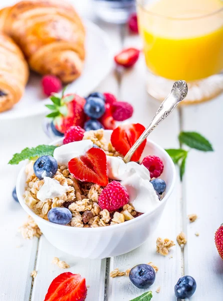 Muesli com iogurte e bagas em uma mesa de madeira. Leite de frutas saudável iogurte e cereais brakfast — Fotografia de Stock