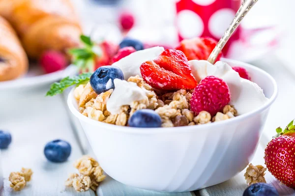 Muesli com iogurte e bagas em uma mesa de madeira. Leite de frutas saudável iogurte e cereais brakfast — Fotografia de Stock