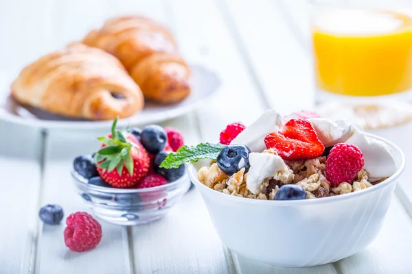 Muesli com iogurte e bagas em uma mesa de madeira. Leite de frutas saudável iogurte e cereais brakfast — Fotografia de Stock