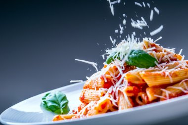 Domates Bolonez Soslu Makarna Penne, Parmesan Peyniri ve Fesleğen Yaprakları. Akdeniz yemekleri. İtalyan mutfağı