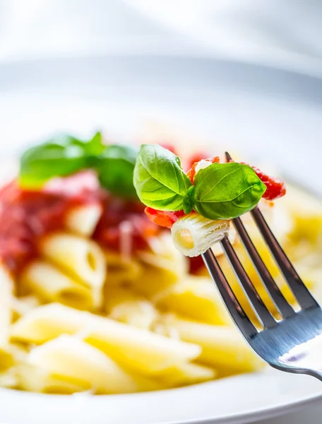 Pasta Penne con salsa boloñesa de tomate, queso parmesano y albahaca en un tenedor. Cocina Mediterránea.Cocina italiana . — Foto de Stock