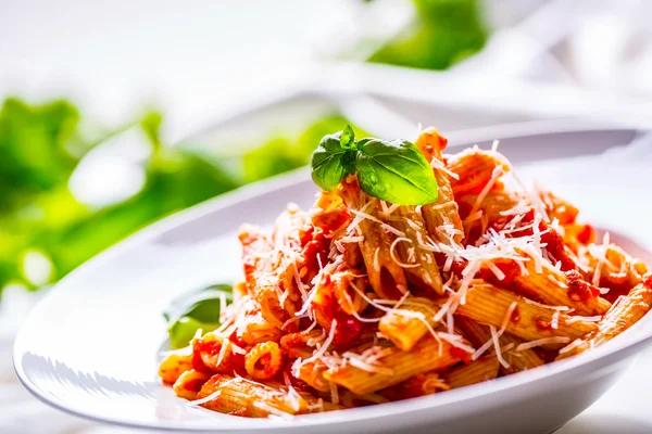 Nudelpenne mit Tomaten-Bolognese-Sauce, Parmesan und Basilikumblättern. mediterrane Lebensmittel. Italienische Küche — Stockfoto