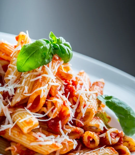 Pasta Penne con salsa boloñesa de tomate, queso parmesano y hojas de albahaca. Cocina Mediterránea.Cocina italiana —  Fotos de Stock