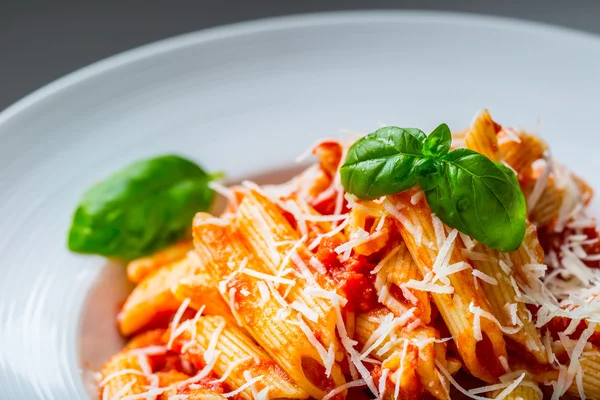 Pasta Penne con salsa boloñesa de tomate, queso parmesano y hojas de albahaca. Cocina Mediterránea.Cocina italiana —  Fotos de Stock