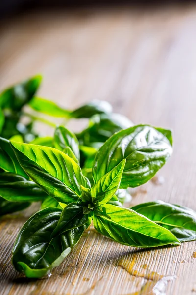 Hojas de albahaca fresca sobre mesa de madera —  Fotos de Stock