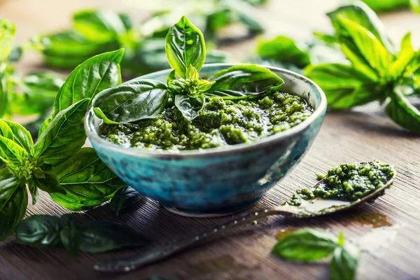 Pesto de folhas de manjericão fresco em mesa de madeira — Fotografia de Stock