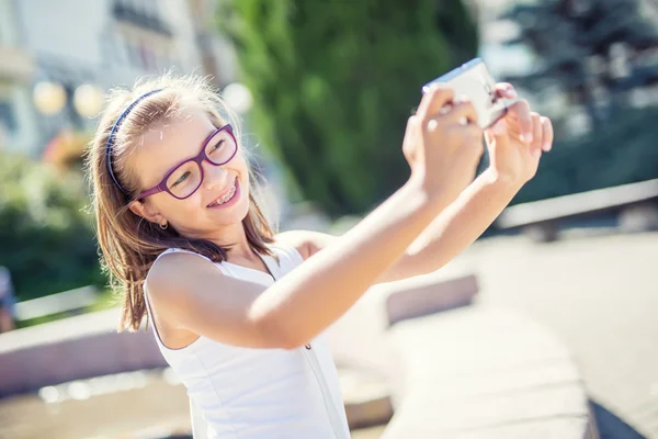 Selfie. Bella ragazza carina con bretelle e occhiali ridere per un selfie — Foto Stock