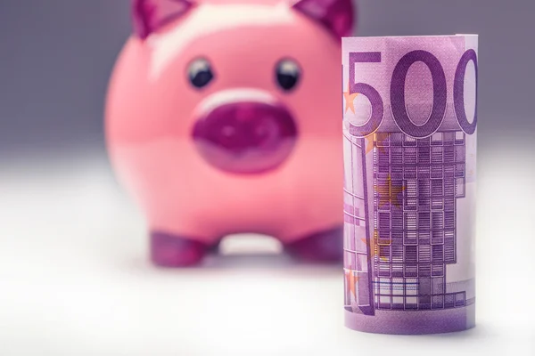 Κουμπαράς. Ροζ γουρουνάκι Αποθήκευση και πεντακόσια χαρτονομίσματα ευρώ. Τονισμένο φωτογραφία — Φωτογραφία Αρχείου