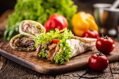 Etli tortilla ve salata. Yanında da daha dolu tortilla ve domates..