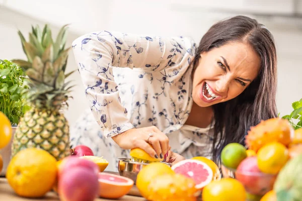 Mujer Apretando Una Naranja Duro Casa Con Montón Fruta Alrededor —  Fotos de Stock