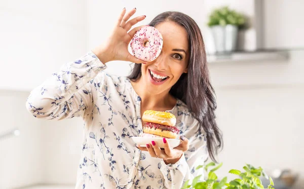 여자가 도넛중 하나에 구멍을 내다보고 있습니다 — 스톡 사진