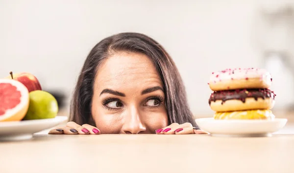 Chica Asoma Por Encima Mesa Mirando Plato Donas Ignorando Fruta — Foto de Stock