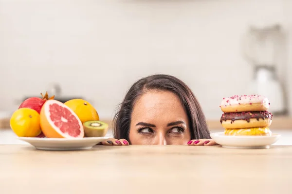 Las Hembras Miran Las Rosquillas Amontonadas Una Mesa Como Opuesto — Foto de Stock