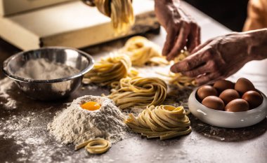 Malzemelerden taze para kazandıktan sonra makarnayı yuvaya çeviren bir şefin elleri..