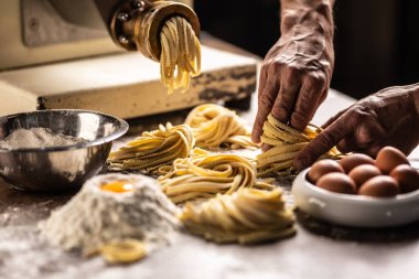 Malzemelerden taze para kazandıktan sonra makarnayı yuvaya çeviren bir şefin elleri..