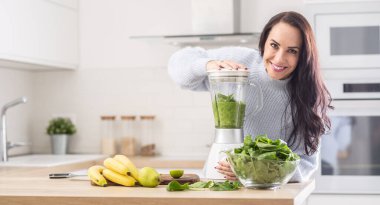 Evde sağlıklı beslenen bir kadın tarafından yapılan yeşil meyve püresi karışımı..