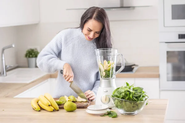 健康饮食中的女性将水果切碎到搅拌机中作为生食混合零食 — 图库照片