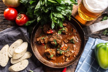 Dolmalık biber, domates, otlar, hamur tatlısı ve bira dolu bir kasede Macar gulaşı..