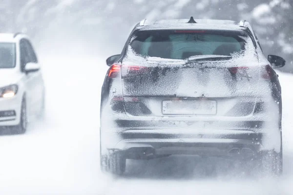 雪のために登録番号が見えない森の中の雪の滑りやすい道でSuv車を運転 — ストック写真