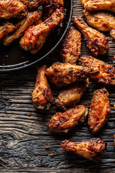 Chicken wings barbeque in a cast iron baking dish - Top of view.