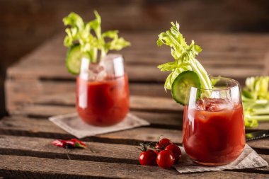 Kereviz çubukları ve vişneli domateslerle servis edilen bir kaba kanlı ya da bakire Mary kokteyli..