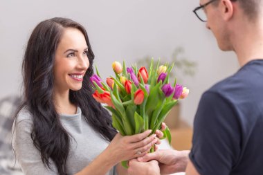 Genç ve güzel bir bayan ulusal kadınlar gününde kocasından ya da erkek arkadaşından bir buket dolusu renkli lale alıyor..