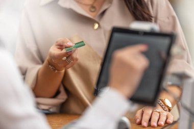 Mağazada alışveriş ödemesi için kredi veya banka kartı sunan bir müşterinin ayrıntıları.