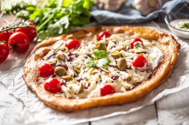 Lezzetli ve kabuklu langolar vişneli domates, rendelenmiş peynir, fasulye ve yeşil Yunan zeytinleriyle mükemmel servis edilir.