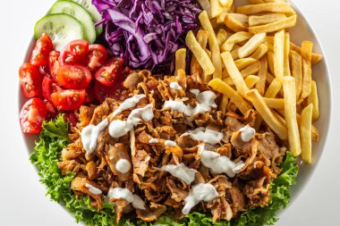 Geleneksel Türk tavuk kebabı güzel patates kızartması, taze sebze ve lezzetli sosla hazırlandı..