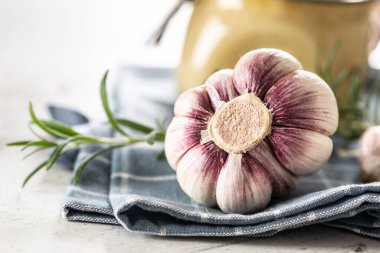 Ev yapımı sarımsak soğanları biberiyeli mutfak bezine serilmiş taze sarımsak ezmesiyle dolu cam bir kavanozun önünde..